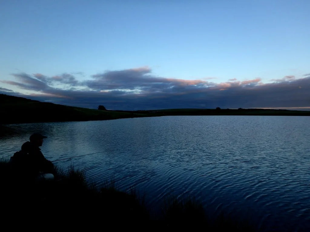 Angler fishing a stillwater at dusk