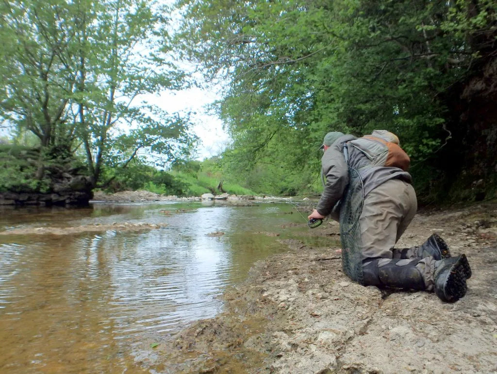 Angler keeping a low profile while fishing a clear shallow river